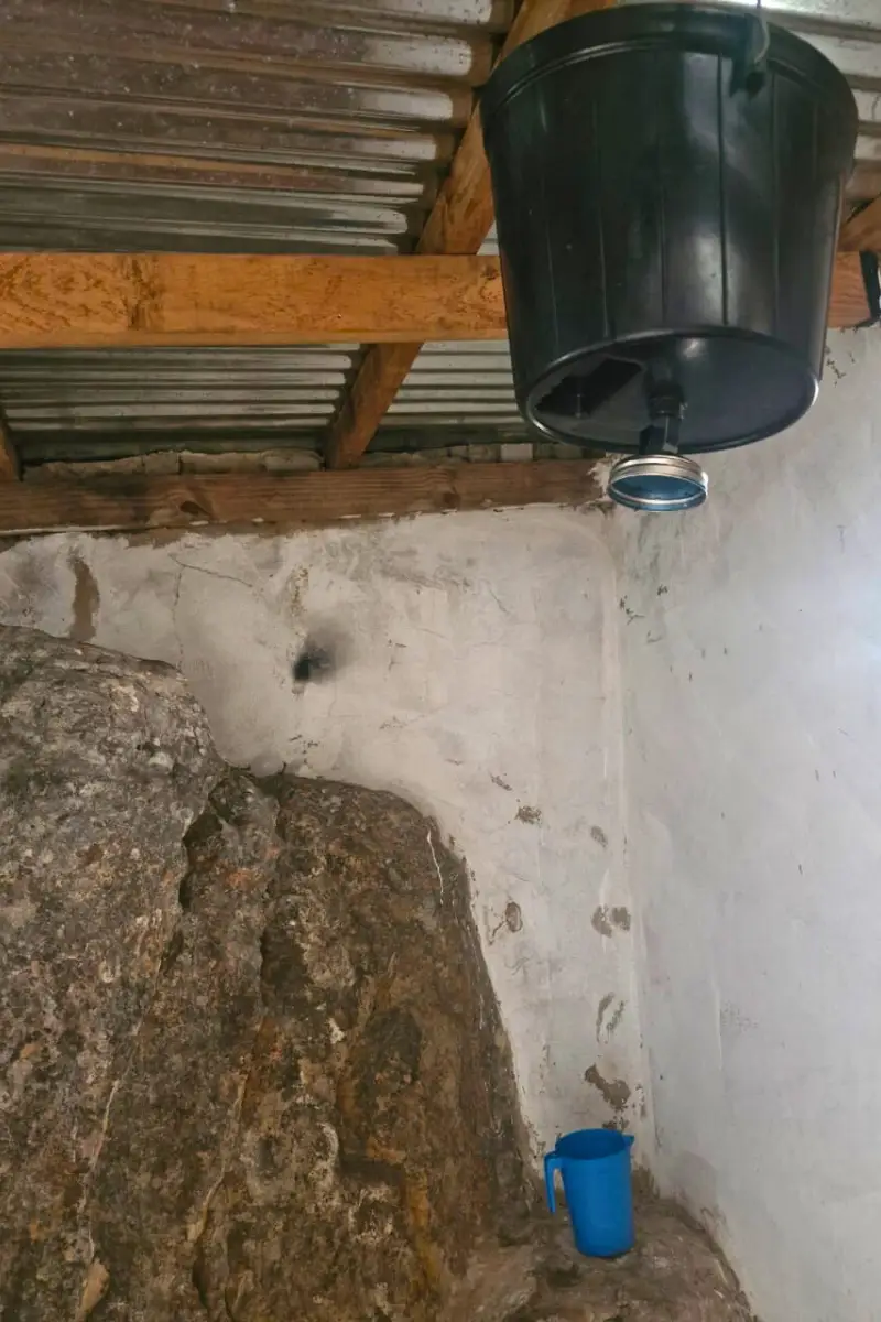 A bucket attached to the ceiling with a shower head
