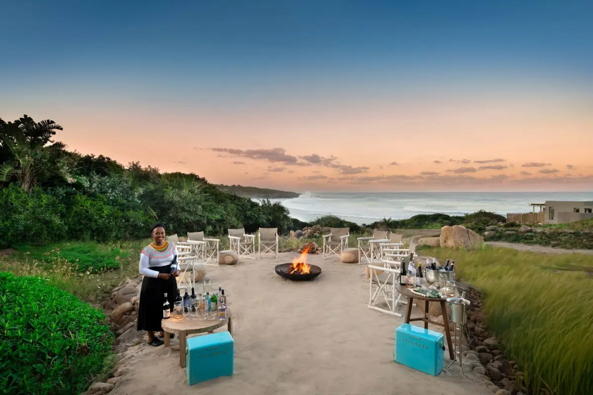 GweGwe staff preparing sundowners at the outdoor fire pit overlooking the ocean