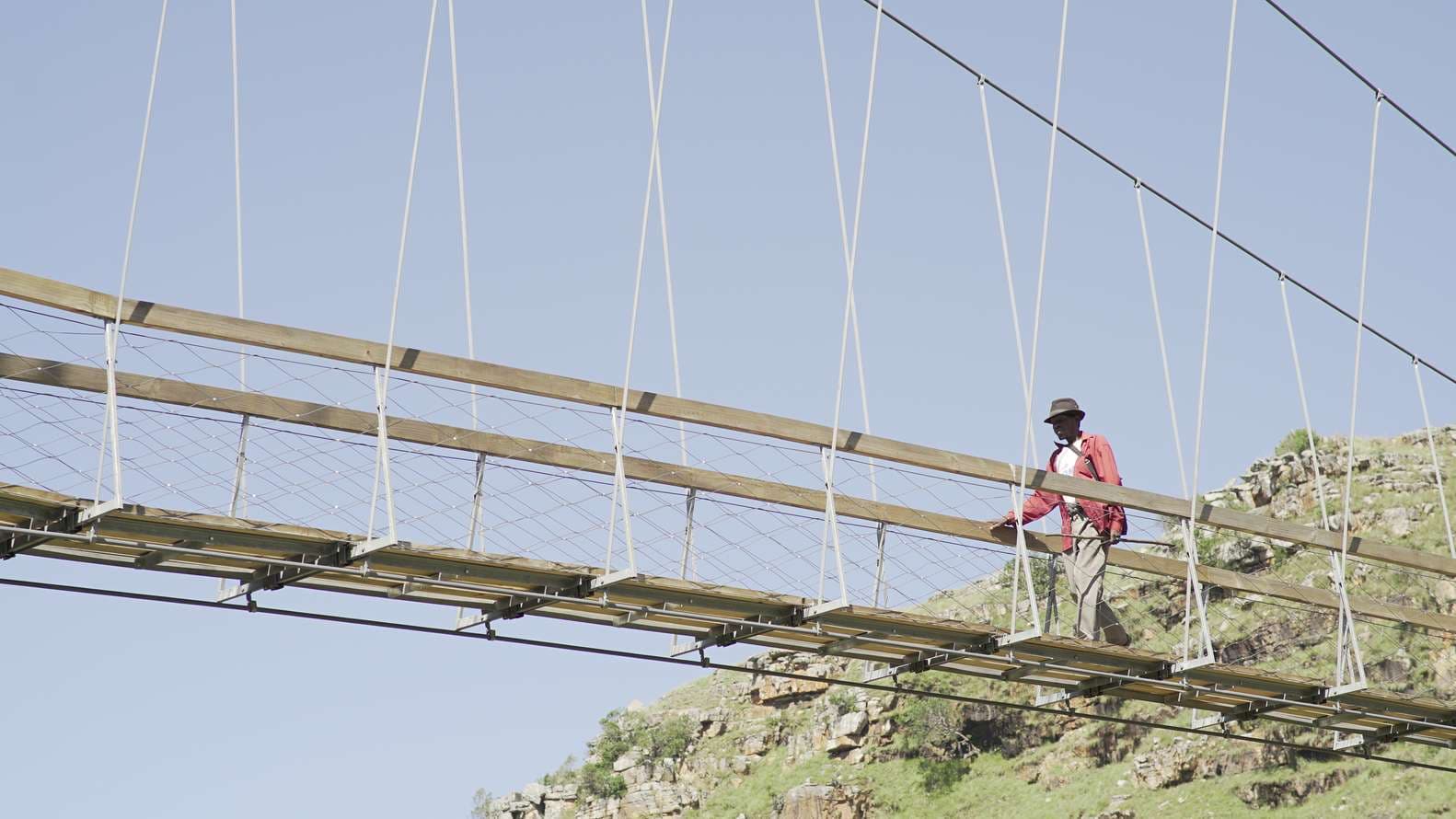 A local community member crossing the Mzamba Pedestrian Bridge