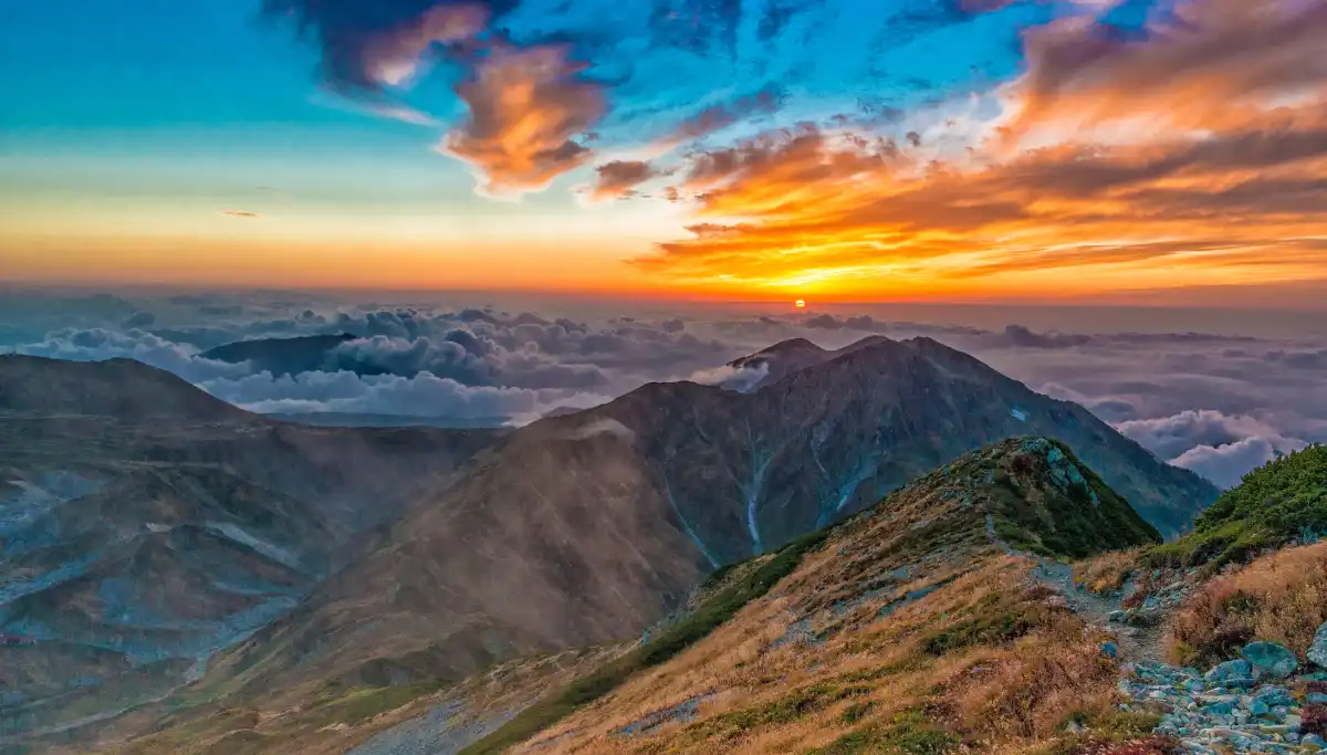 Vivid orange sunrise over mountain ridgeline, ideal conditions for early morning hiking in South Africa