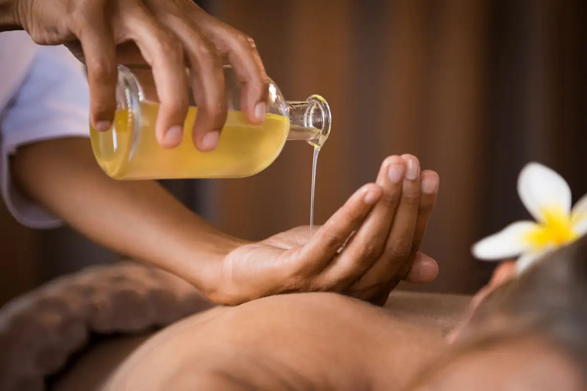 Massage oil being poured during a spa treatment